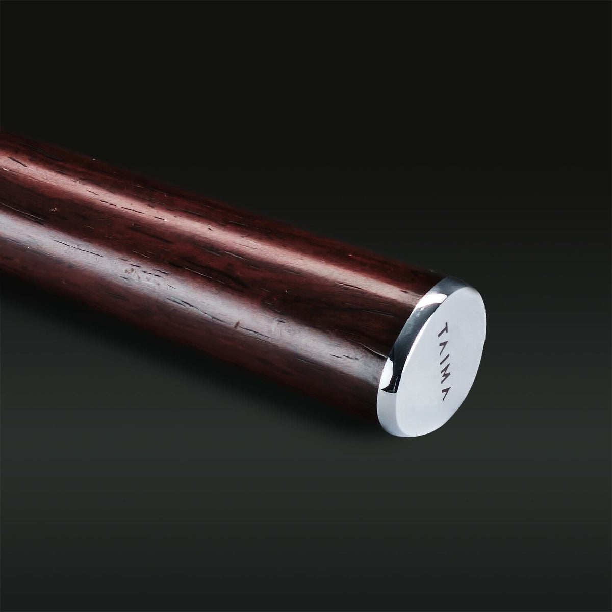 Wooden stick with a silver cap on a black background