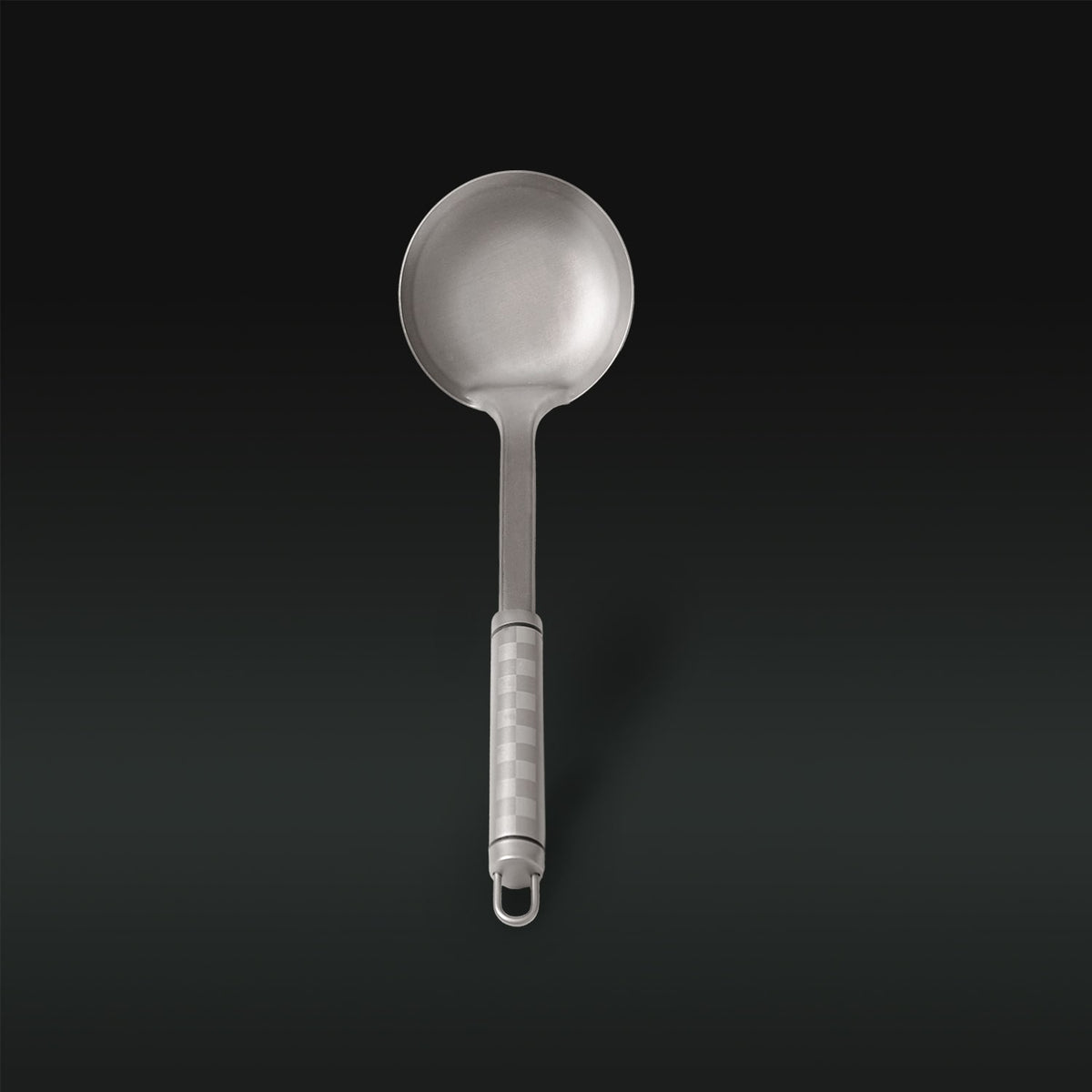 Metallic ladle with a textured handle on a black background