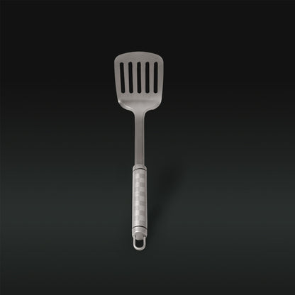 Metallic slotted spatula on a black background