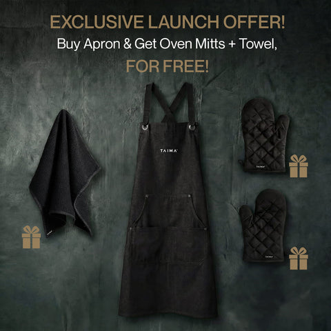 Black apron with oven mitts and towel on a dark background, featuring TAIMA branding.