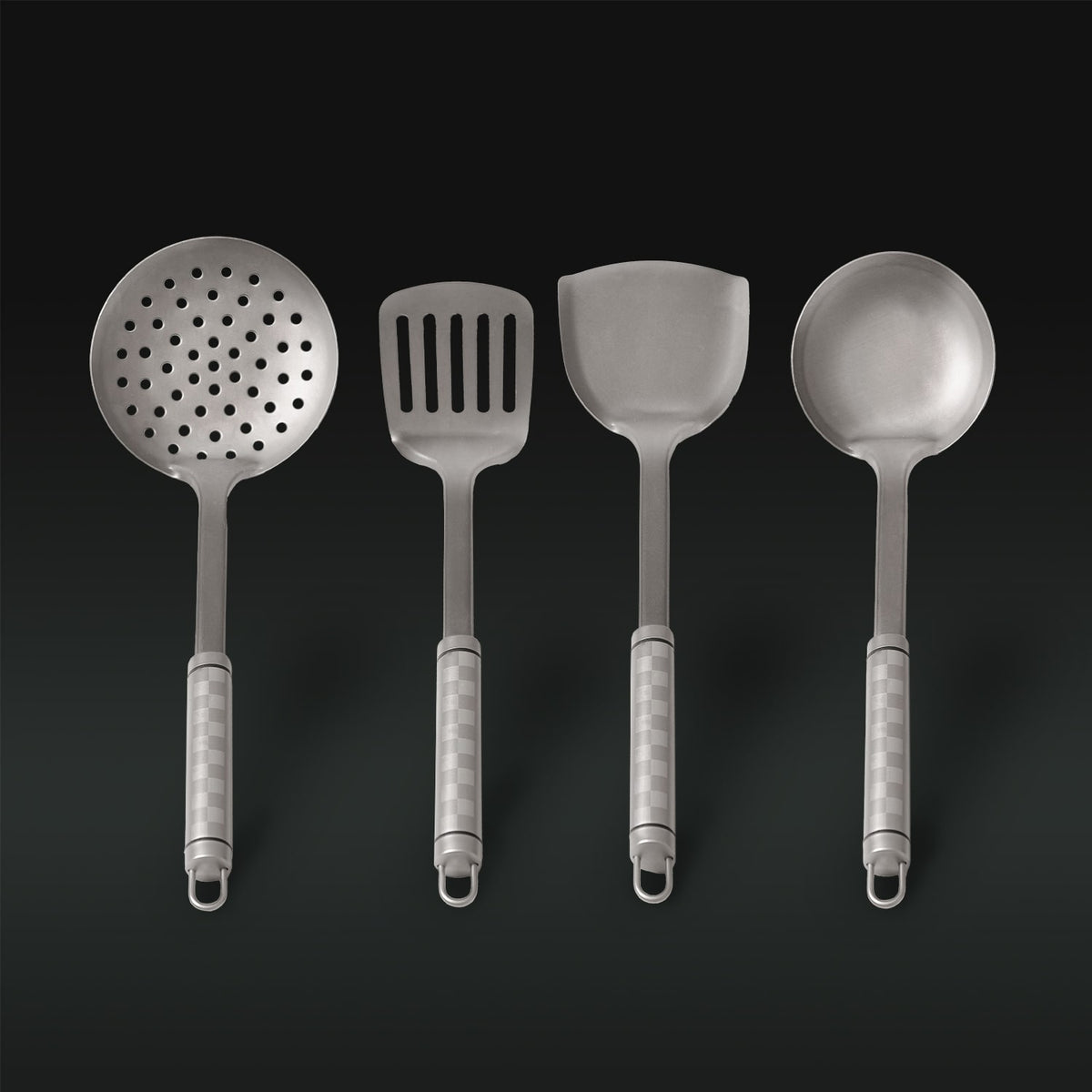 Set of four titanium kitchen utensils on a dark background