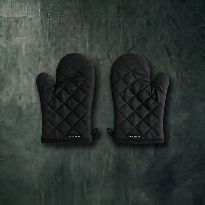 Pair of black quilted oven mitts on a dark textured surface