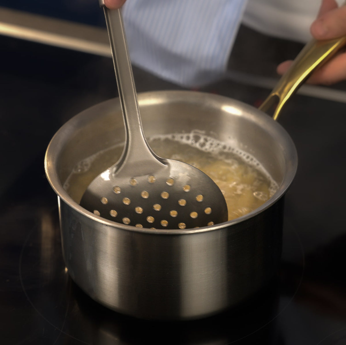 Stirring a pot of boiling liquid with titanium utensils